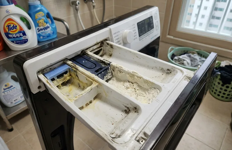 세탁기 세제 투입구 내부에 남은 세제 잔여물과 물때