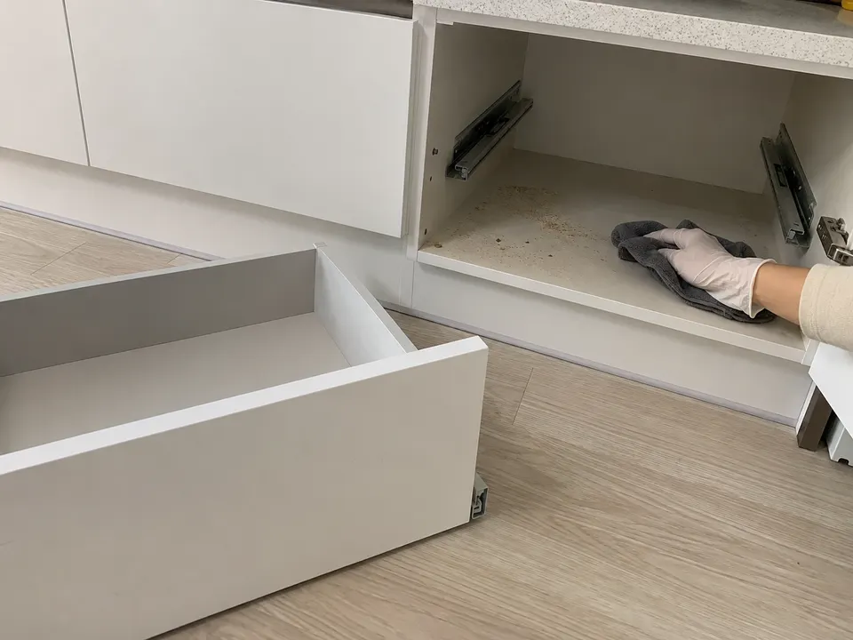 서랍을 탈거한 주방 수납장 안쪽 분진을 닦는 모습