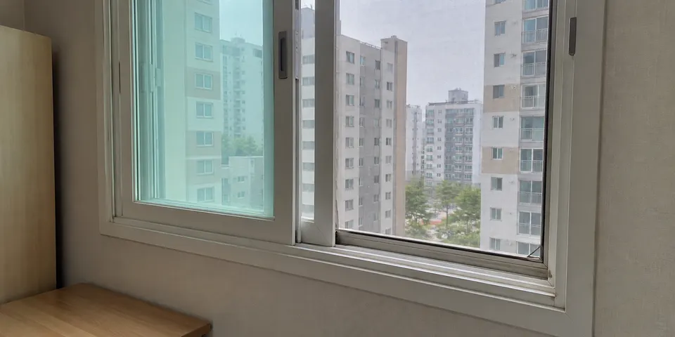 한국 아파트 작은 방 창문에 설치된 방충망과 창틀
